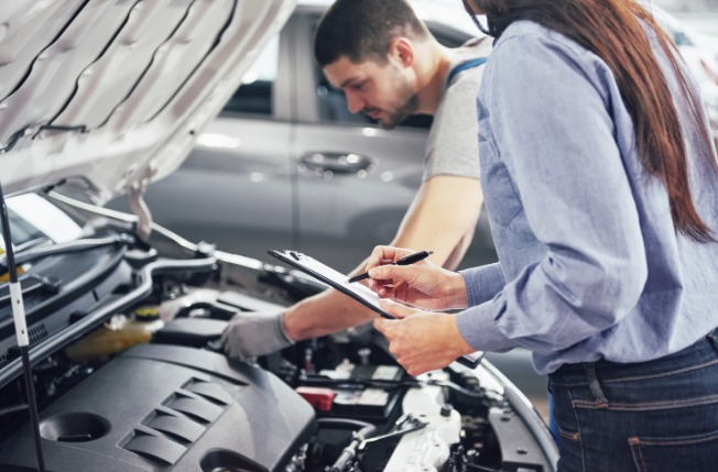 personal revisando la tecnicomecanica de un carro
